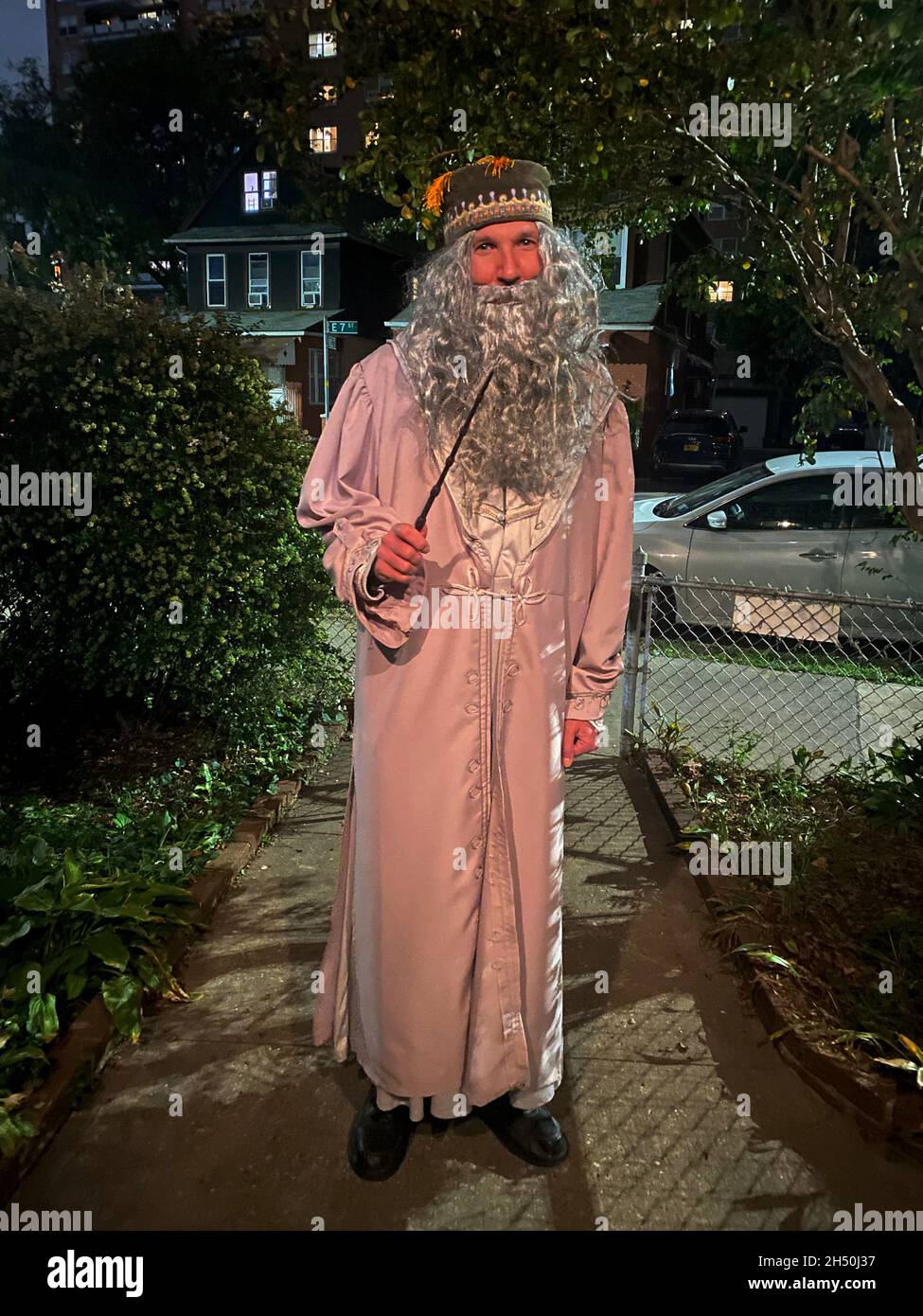 Ritratto di un uomo che va ad una festa di Halloween come il mago Dumbledore dai libri di Harry Potter. Sera, Brooklyn, New York. Foto Stock