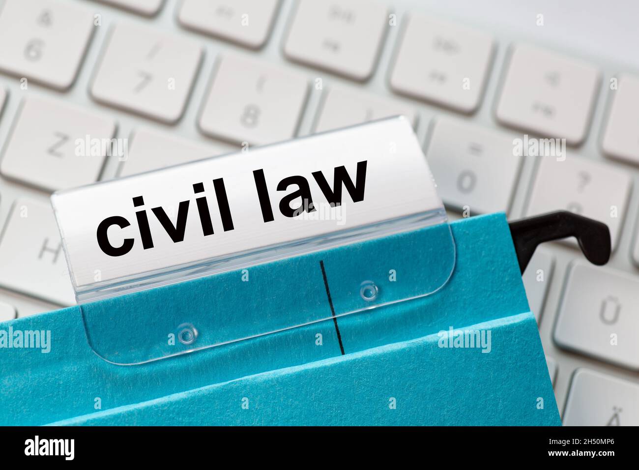 la legge civile è su un'etichetta di un archivio blu appeso. In background una tastiera del computer Foto Stock
