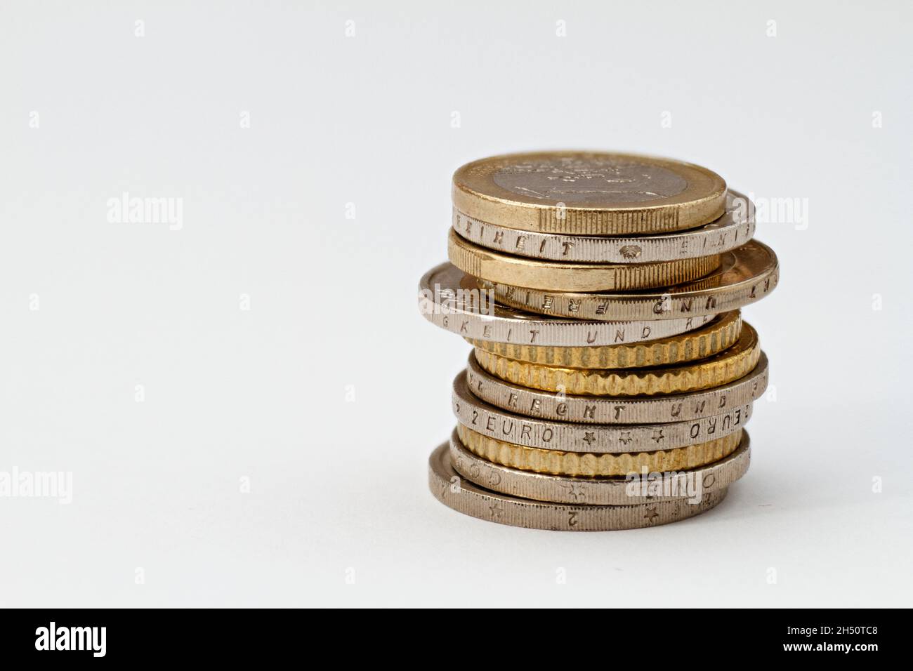 Una pila di monete che sono isolate su uno sfondo bianco. Spazio per il testo Foto Stock