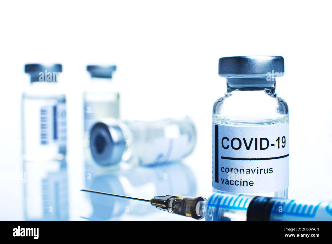Flaconcino di vetro con etichetta di vaccino del coronavirus e closeup della siringa Foto Stock