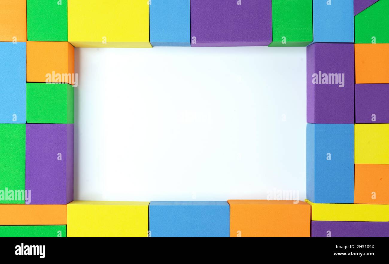 Cornice di quadratini, rettangoli e triangoli multicolore con centro bianco. Foto Stock