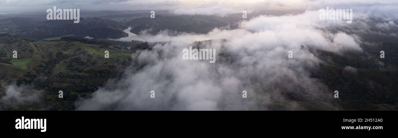 Le nuvole basse si distolano sulle colline che si trovano ad est della Baia di San Francisco, California. Questa regione secca diventa verde durante i mesi invernali a causa della pioggia. Foto Stock