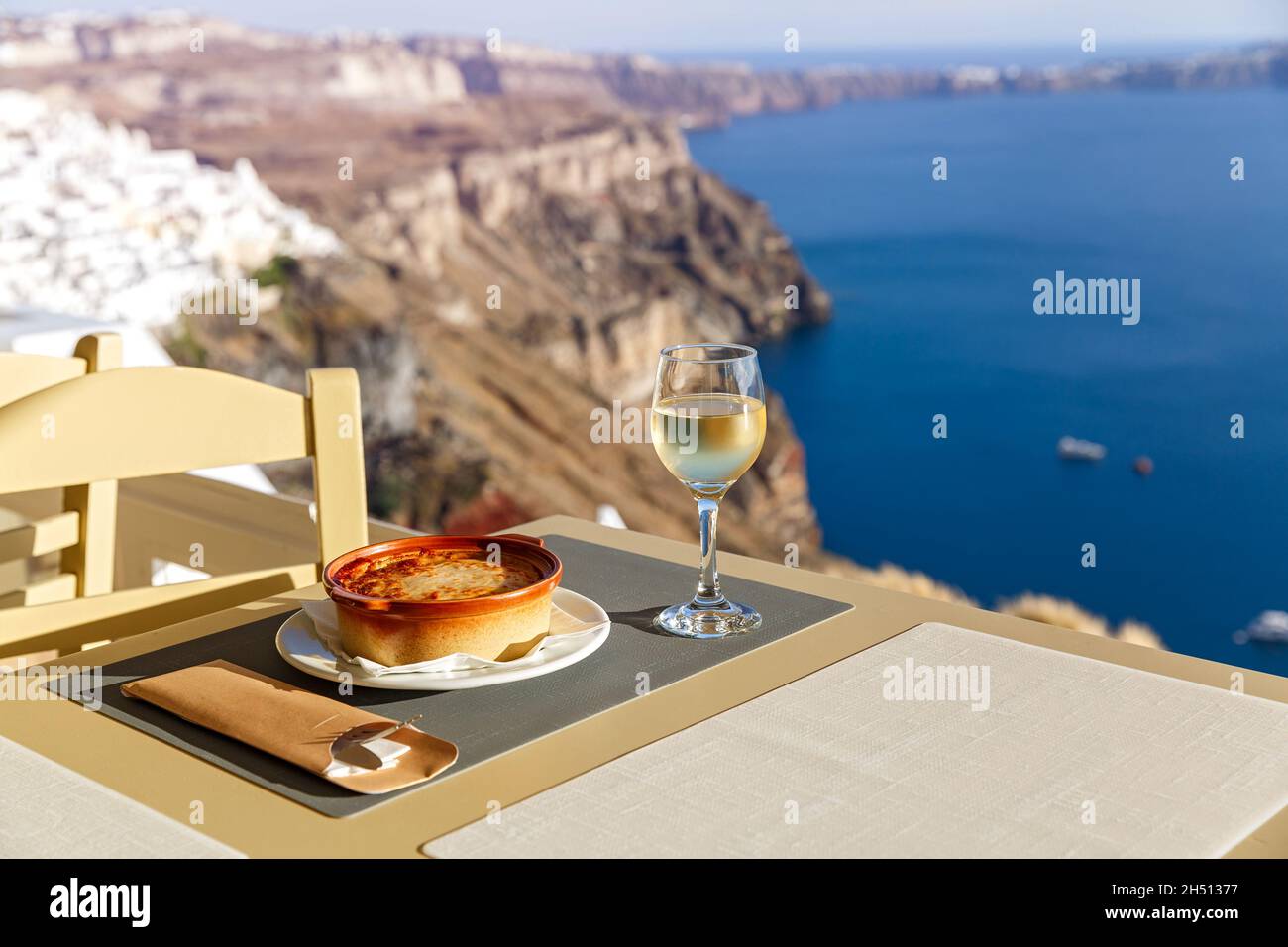 Cena in un ristorante che si affaccia sul mare e sull'isola di Santorini, in Grecia Foto Stock