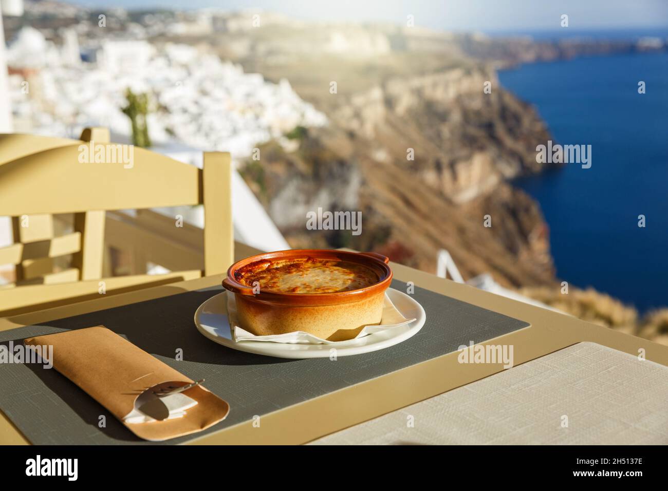 Cena in un ristorante che si affaccia sul mare e sull'isola di Santorini, in Grecia Foto Stock