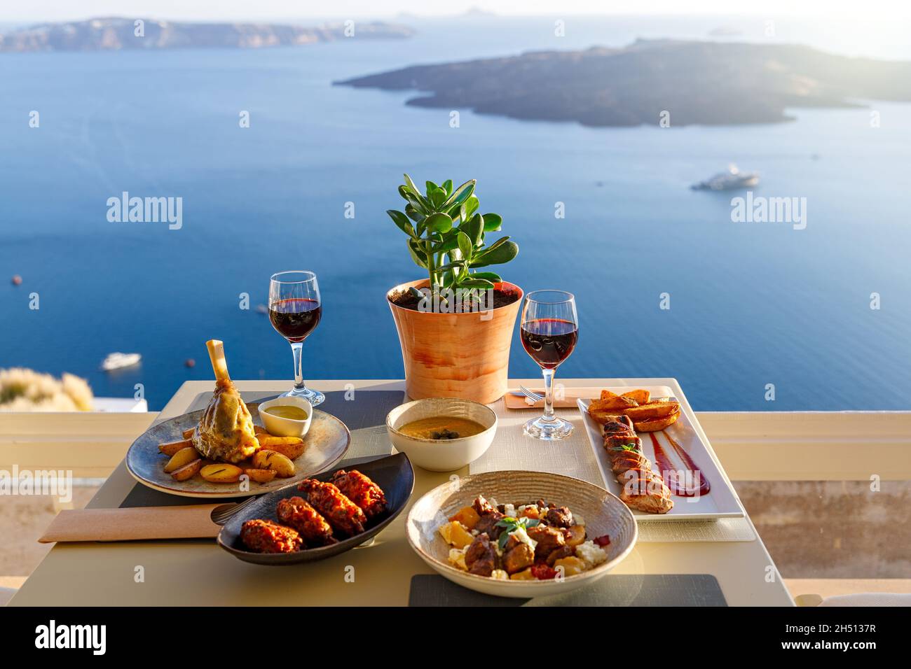 Cena per due in un ristorante affacciato sul mare e sull'isola di Santorini, Grecia Foto Stock