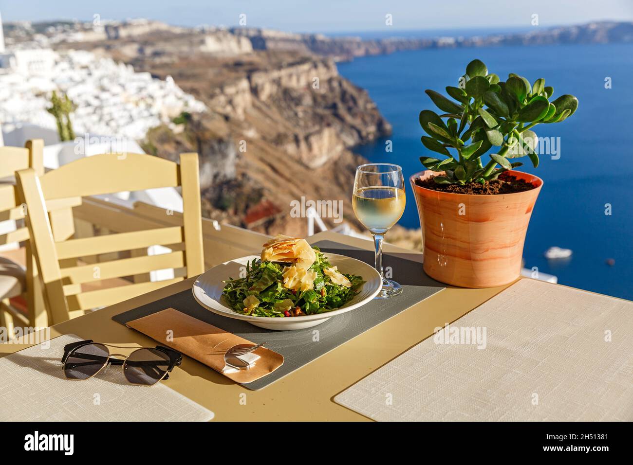 Cena in un ristorante affacciato sul mare e sull'isola di Santorini, Grecia Foto Stock