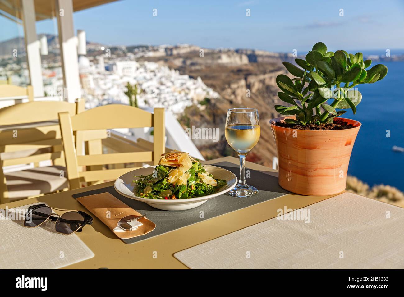 Cena in un ristorante affacciato sul mare e sull'isola di Santorini, Grecia Foto Stock