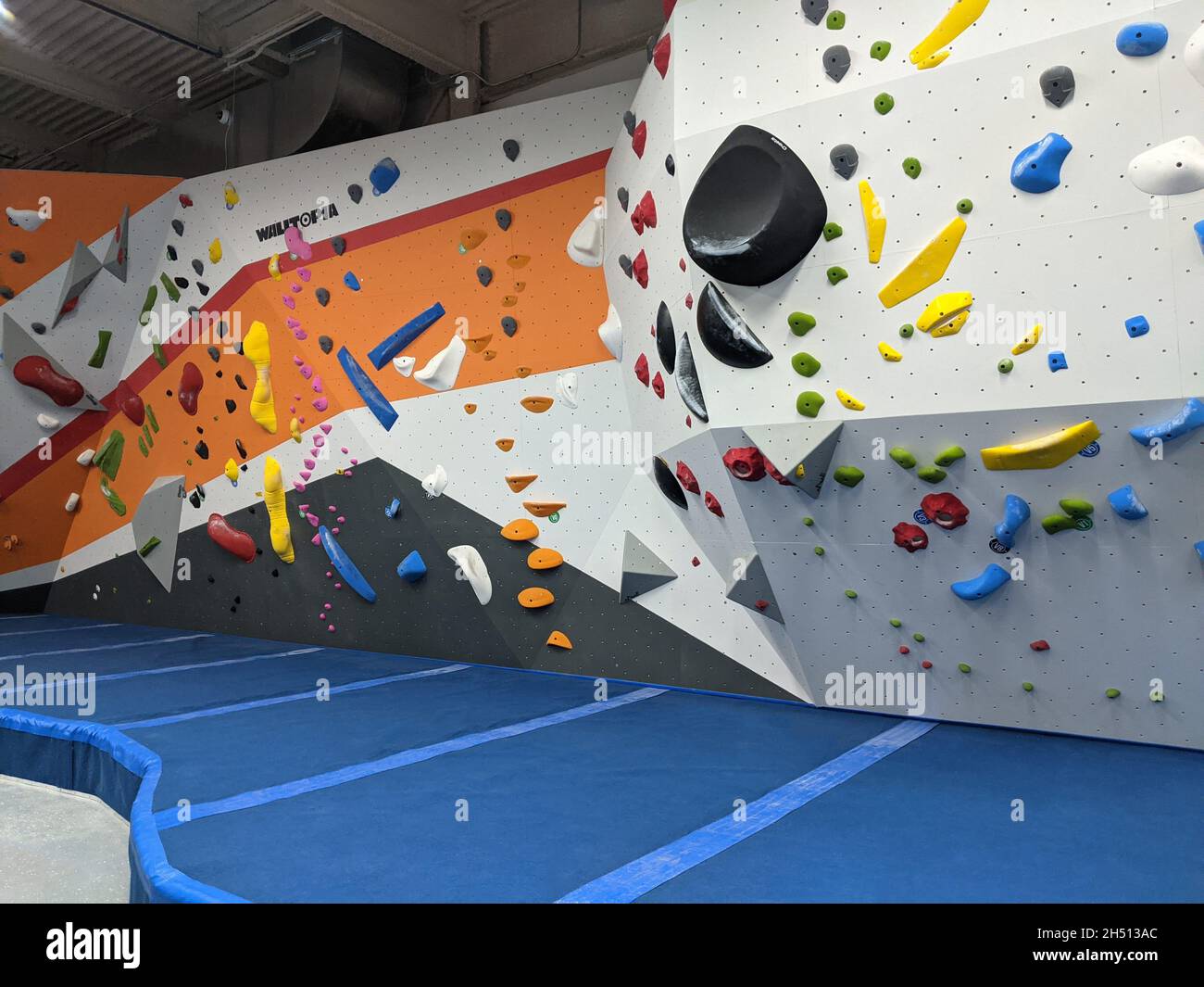 Bouldering interno e parete di arrampicata per l'allenamento in una palestra moderna Foto Stock