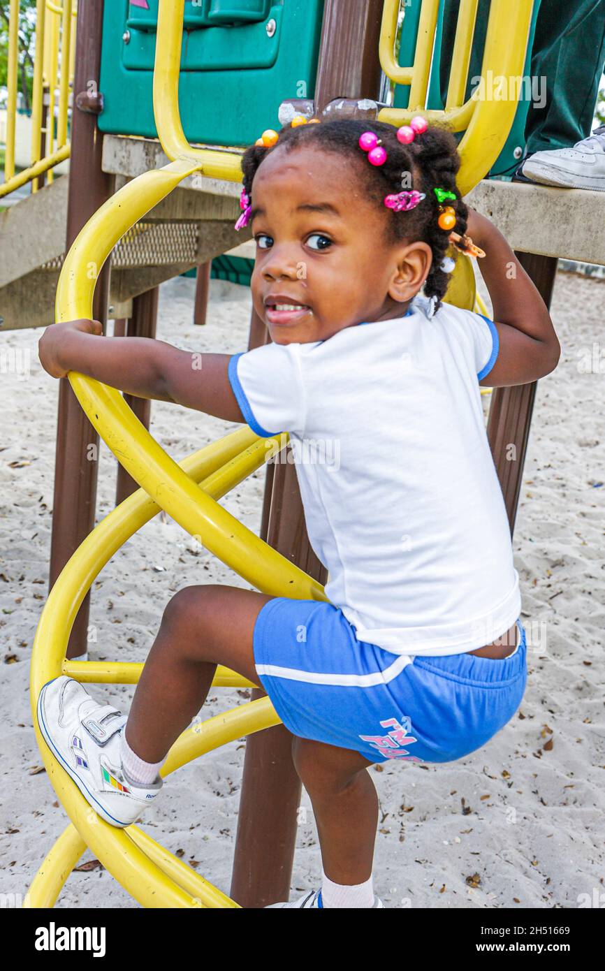 Miami Florida, Liberty City, African Square Park, centro città a basso reddito femminile parco giochi per bambini arrampicata attiva Foto Stock