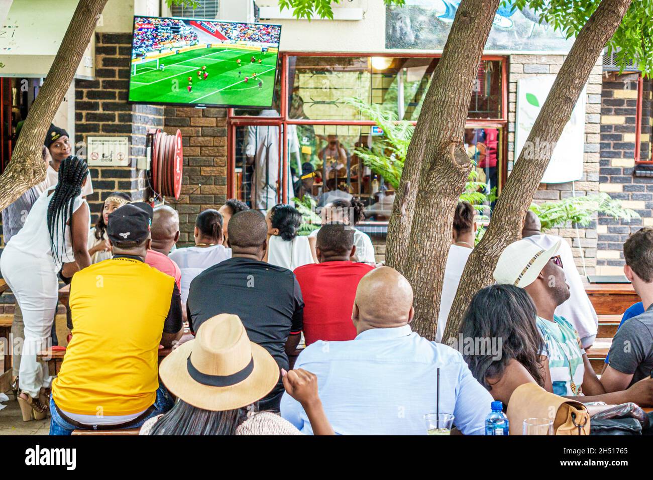 Johannesburg Sud Africa, Soweto Vilakazi Street Precinct Sakhumzi ristorante, uomini neri donne che guardano la partita di calcio, football futbol grande schermo TV Foto Stock