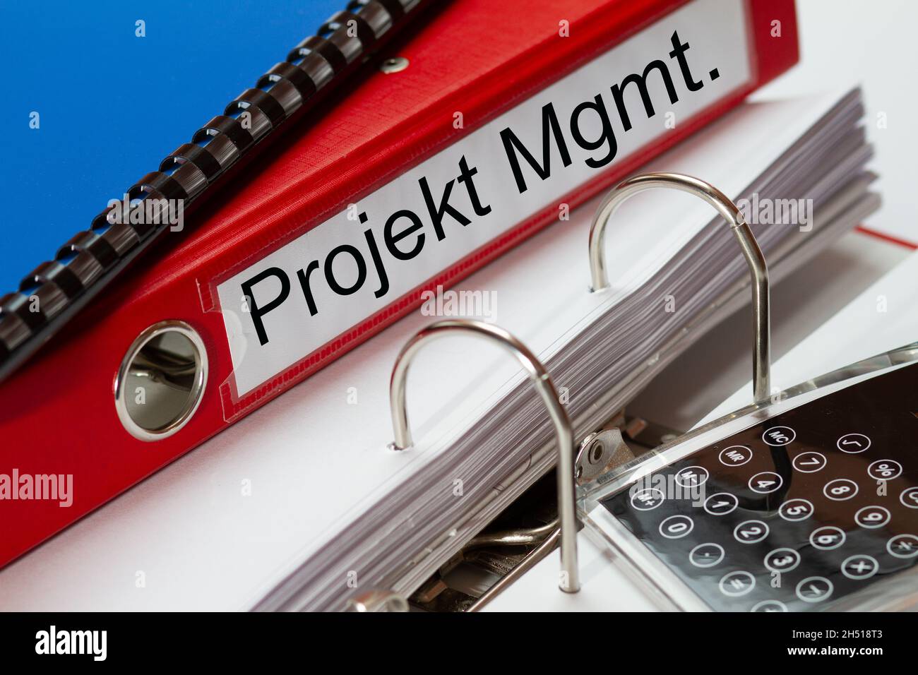 Grande cartella rossa per la gestione dei progetti in tedesco, inclusa la  rilegatrice ad anelli blu e la calcolatrice tascabile Foto stock - Alamy