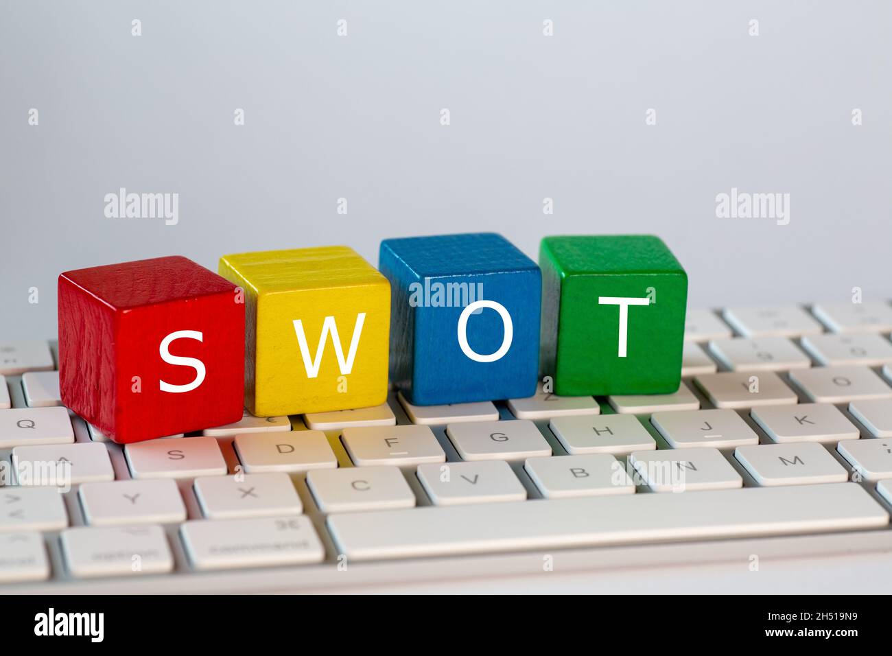 Le lettere SWOT sono punti di forza, punti deboli, opportunità e minacce. Queste lettere sono scritte in bianco su blocchi rossi, gialli, blu e verdi Foto Stock