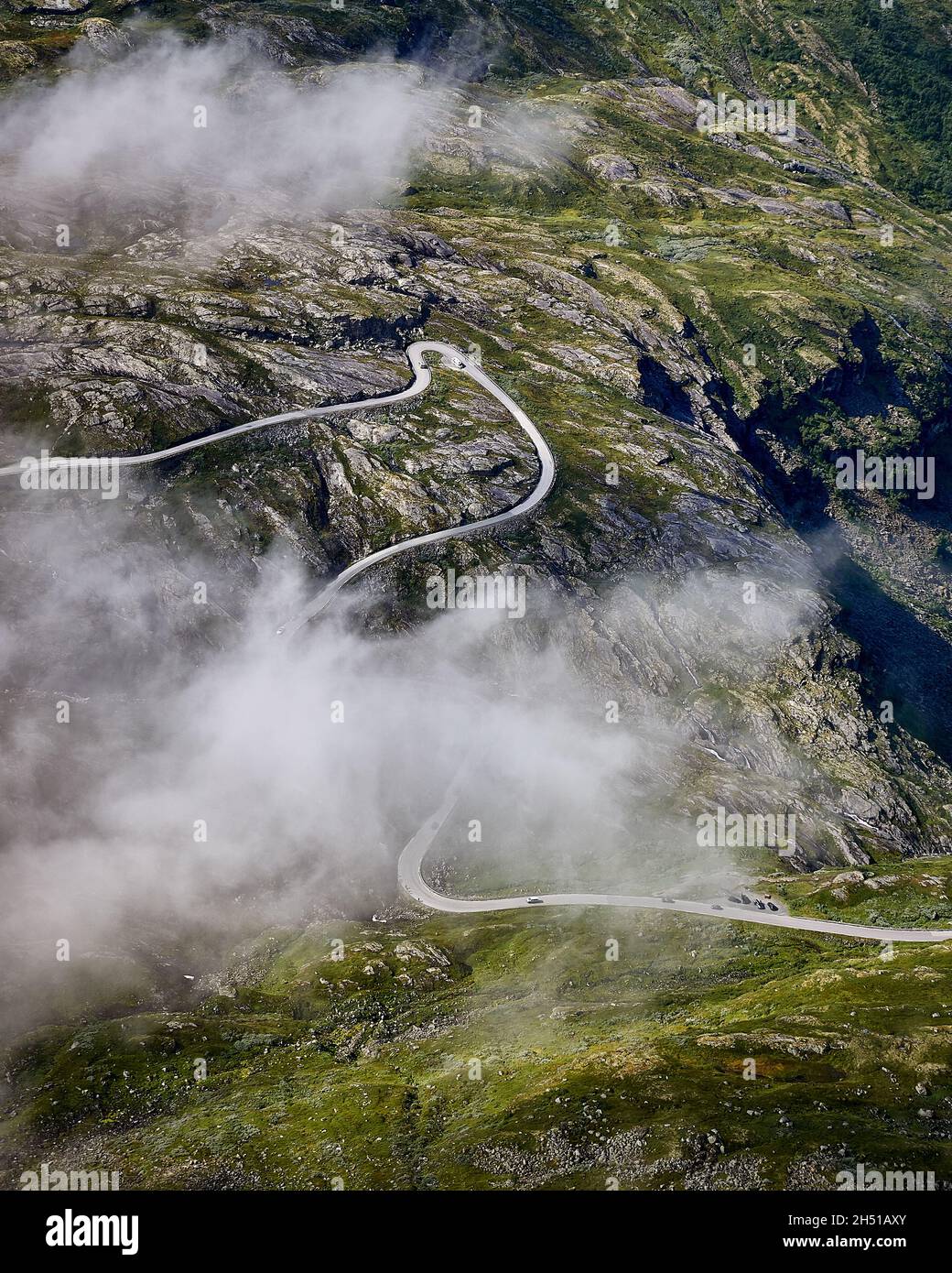 Vista verso il basso verso la strada coperta nuvolosa che conduce fino a Dalsnibba, Geiranger, Norvegia Foto Stock