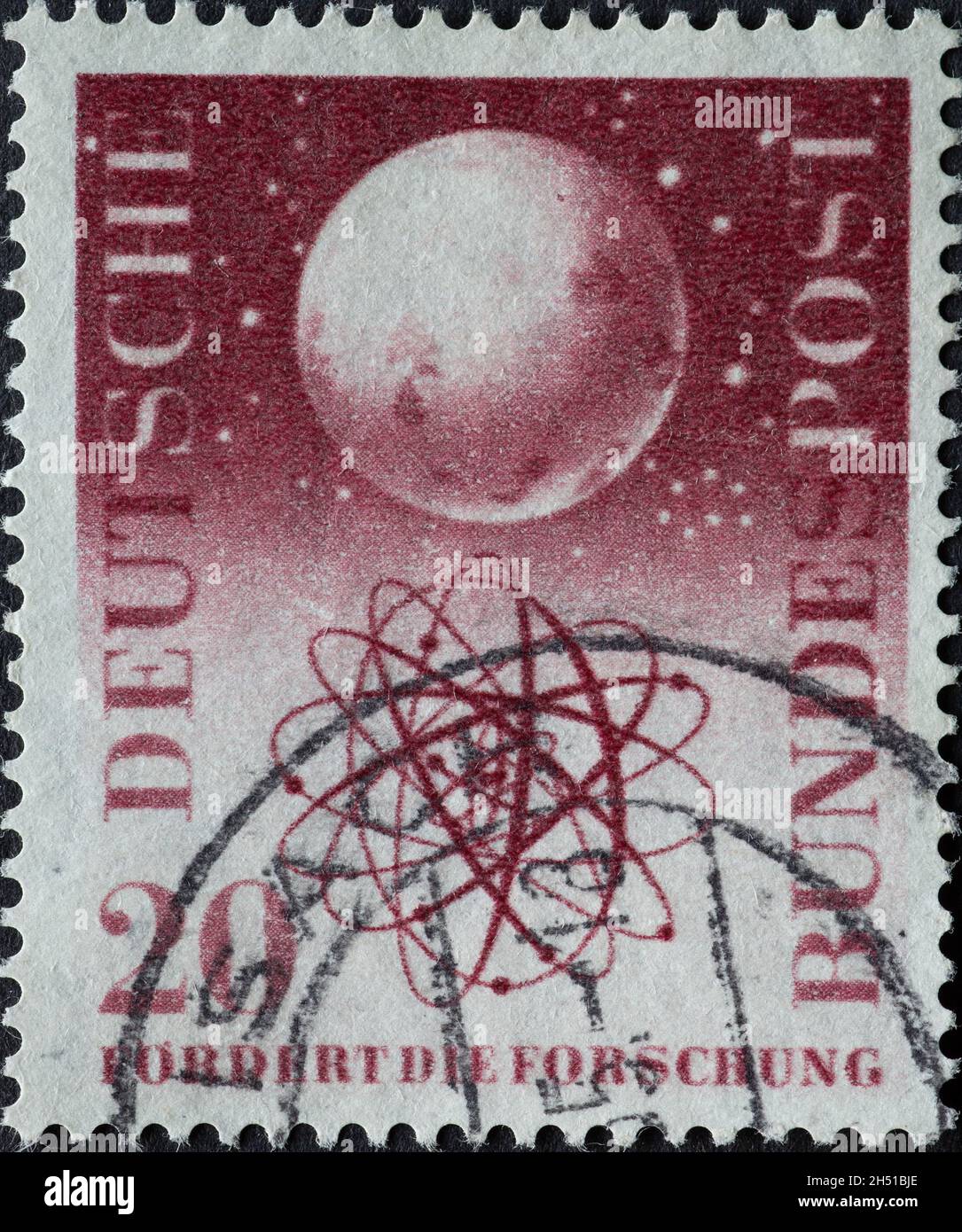 GERMANIA - CIRCA 1955: Questo francobollo mostra un globo e un modello di atomo e il testo promuove la ricerca. Circa 1955 Foto Stock