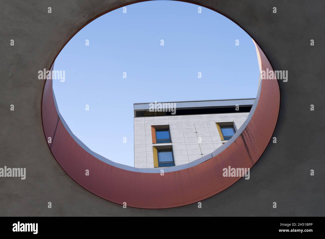 Forma della finestra circolare sul tetto che guarda in cielo azzurro chiaro e finestre sqaure dell'appartamento Londra Inghilterra UK Foto Stock