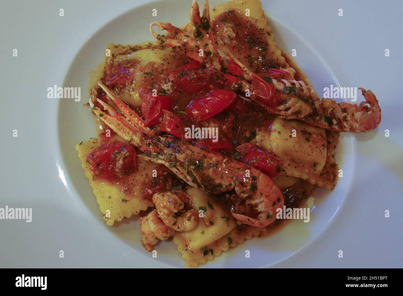 Ravioli con frutti di mare ottimo primo piatto da gustare guardando il mare e bevendo vino bianco fresco. Foto Stock