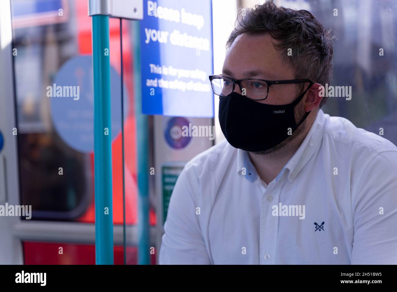 Face Covered Traveller su DLR train London England UK Foto Stock