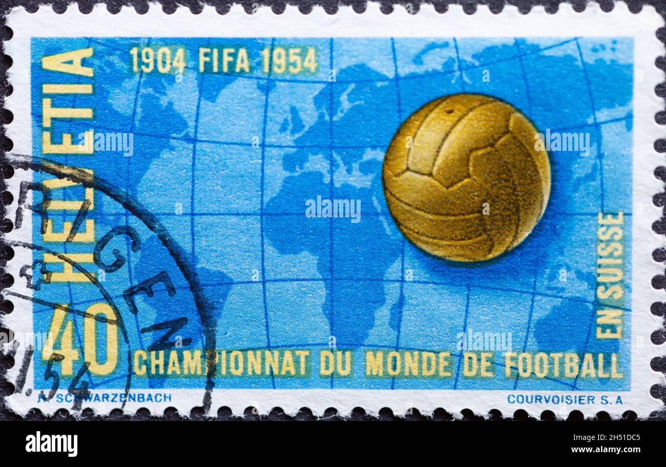 Svizzera - Circa 1954 : francobollo stampato in svizzera che mostra una palla di calcio e una mappa del mondo (Coppa del mondo di calcio 1954 a Losanna e Berna Foto Stock