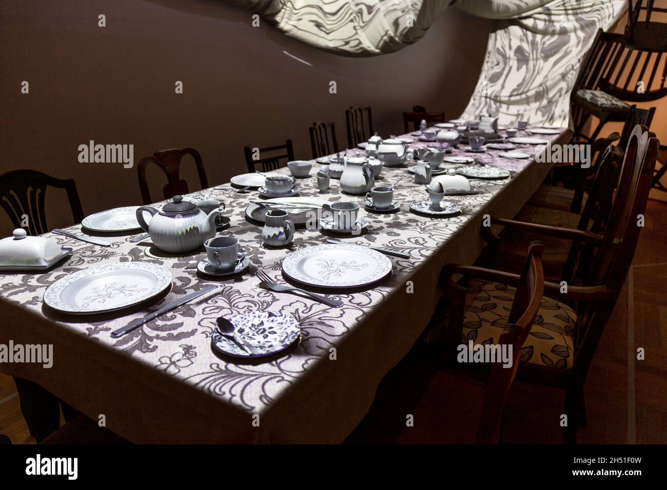 Heston Blumenthal e la riimmaginazione di Dave Mckean della festa del tè di Mad Hatter, i modelli sono proiettati su stoviglie bianche, "Alice: Curiouser and Curiouser" 2021 alla V&A di Londra, Regno Unito Foto Stock