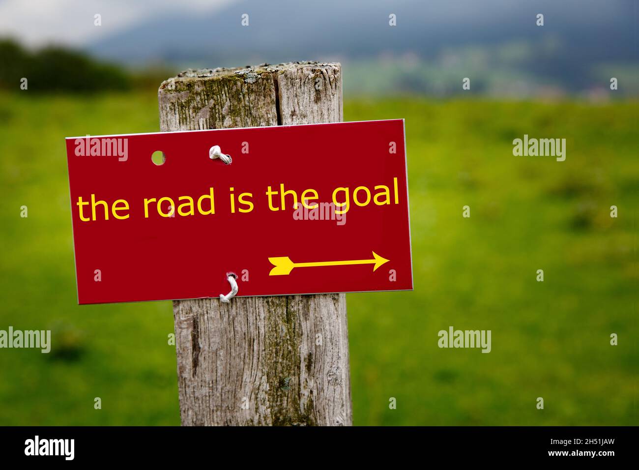 segno rosso nelle alpi con il testo: la strada è la meta Foto Stock