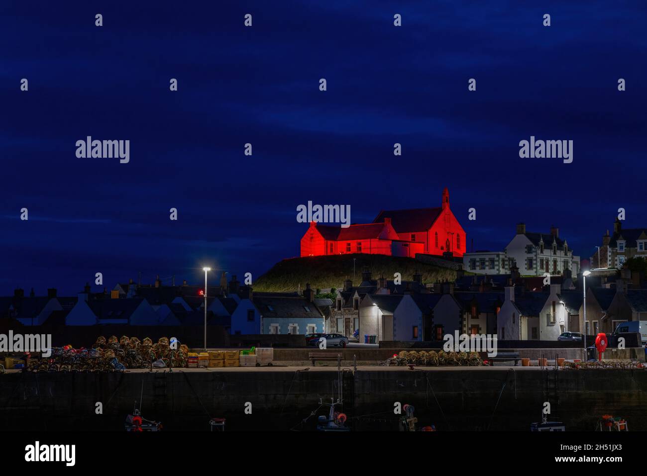 FINDOCHTY, MORAY, REGNO UNITO. 5 novembre 2021. Questa è la Chiesa che si affaccia sul porto e che si illuminava di rosso per Poppy Appeal Scotland a Findochty, Moray, Scozia, Regno Unito il 5 novembre 2021. Credit: JASPERIMAGE/Alamy Live News Foto Stock