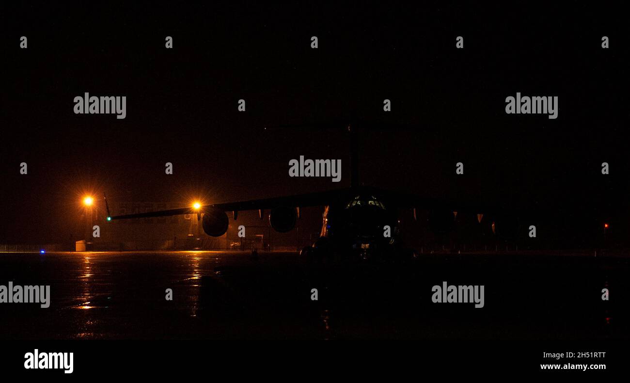Un C-17 Globemaster III siede su una rampa durante l'esercizio Rainier War 21B alla Joint base Lewis-McChord, Washington, 3 novembre 2021. Rainier War è un grande esercizio semestrale di preparazione guidato dalla 62a Ala Airlift, progettato per formare gli equipaggi in scenari realistici che supportano operazioni di preparazione a tutto spettro contro le minacce moderne e replicano le attuali operazioni di emergenza. (STATI UNITI Air Force foto di staff Sgt. Tryphena Mayhugh) Foto Stock