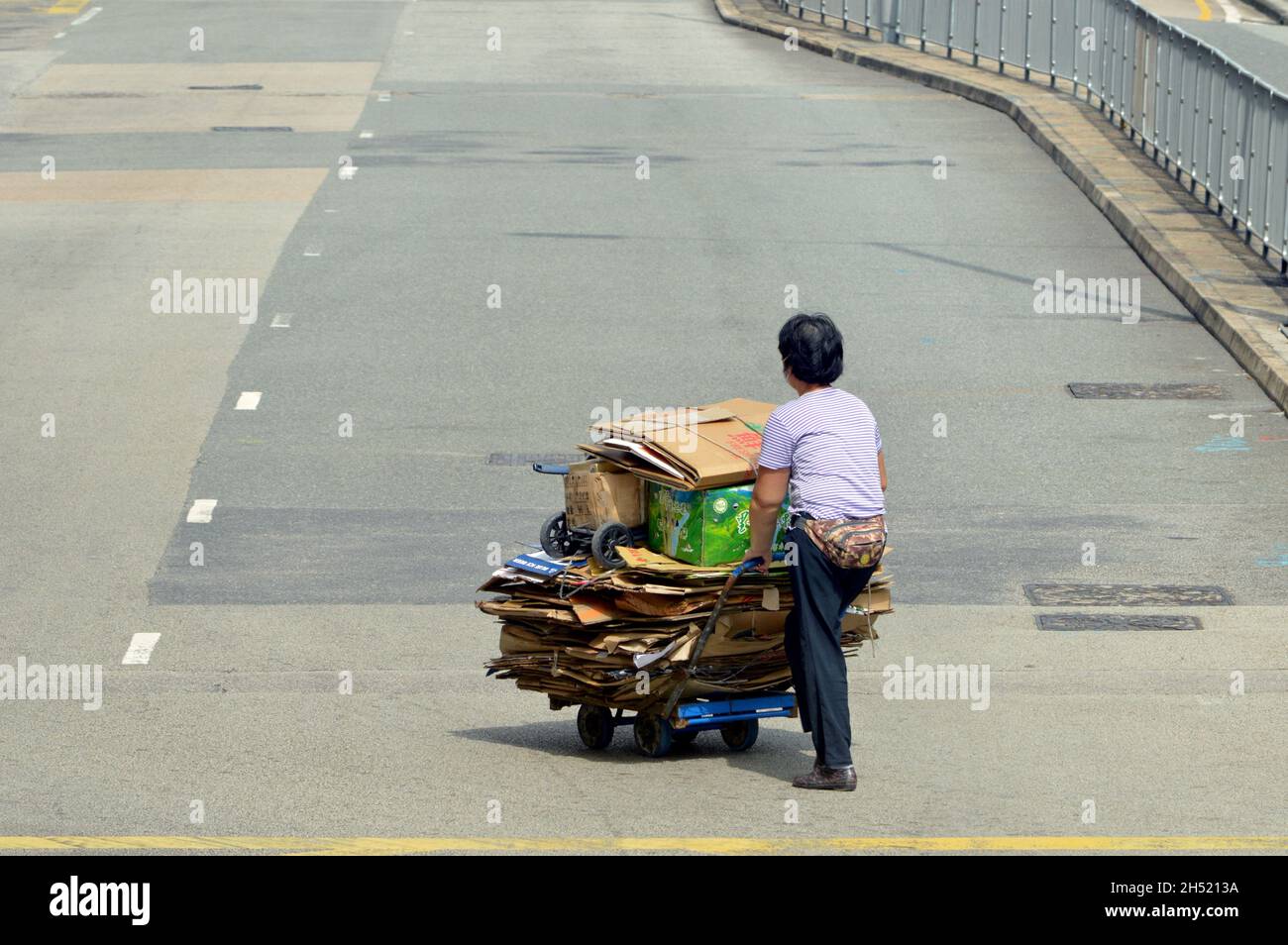 Collettore di cartone che attraversa la strada a Hung Hom, Kowloon, Hong Kong Foto Stock