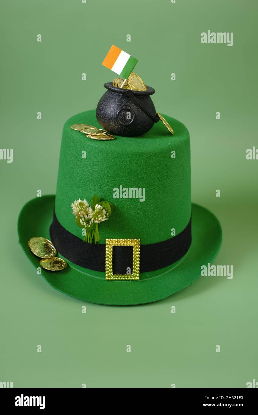 San Patrizio sfondo. St.Patrick's Day.Green cappello leprechaun, bandiera d'Irlanda, moneta d'oro, mazzo di chiodi di garofano su sfondo verde. San Patrizio Foto Stock