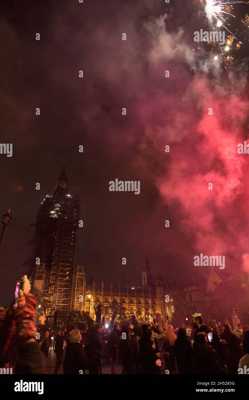 Londra, Regno Unito. 05 novembre 2021. I fuochi d'artificio scendono al Parlamento durante la celebrazione annuale della notte Guy Fawkes. La notte Guy Fawkes è una celebrazione annuale in memoria del Gunpowder Plot, un tentativo di bruciare il Parlamento a Londra il 5 novembre 1605. La protesta è stata tenuta dal gruppo hacktivist anti-establishment Anonymous. I dimostranti sono visti che settano fuochi d'artificio e bombe a gas fuori dal Parlamento mentre indossano la maschera Guy Fawkes. (Foto di Belinda Jiao/SOPA Images/Sipa USA) Credit: Sipa USA/Alamy Live News Foto Stock