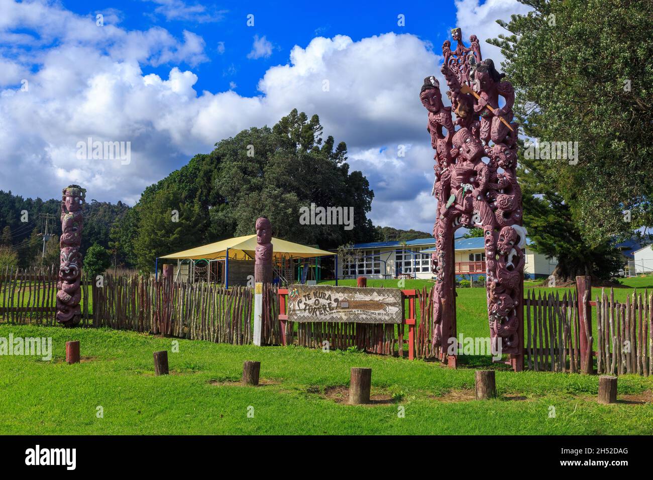 Te Kura o Torere, una scuola nella piccola città di Torere, Nuova Zelanda. La recinzione della scuola è decorata con elaborati intagli Maori Foto Stock