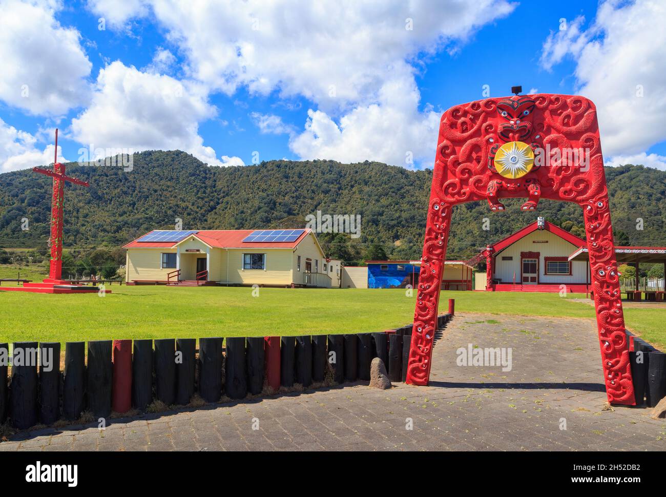 Otuwhare Marae, un punto di incontro Maori nel remoto villaggio di Omaio, Nuova Zelanda. All'entrata si trova un arco colorato con intagli Maori Foto Stock