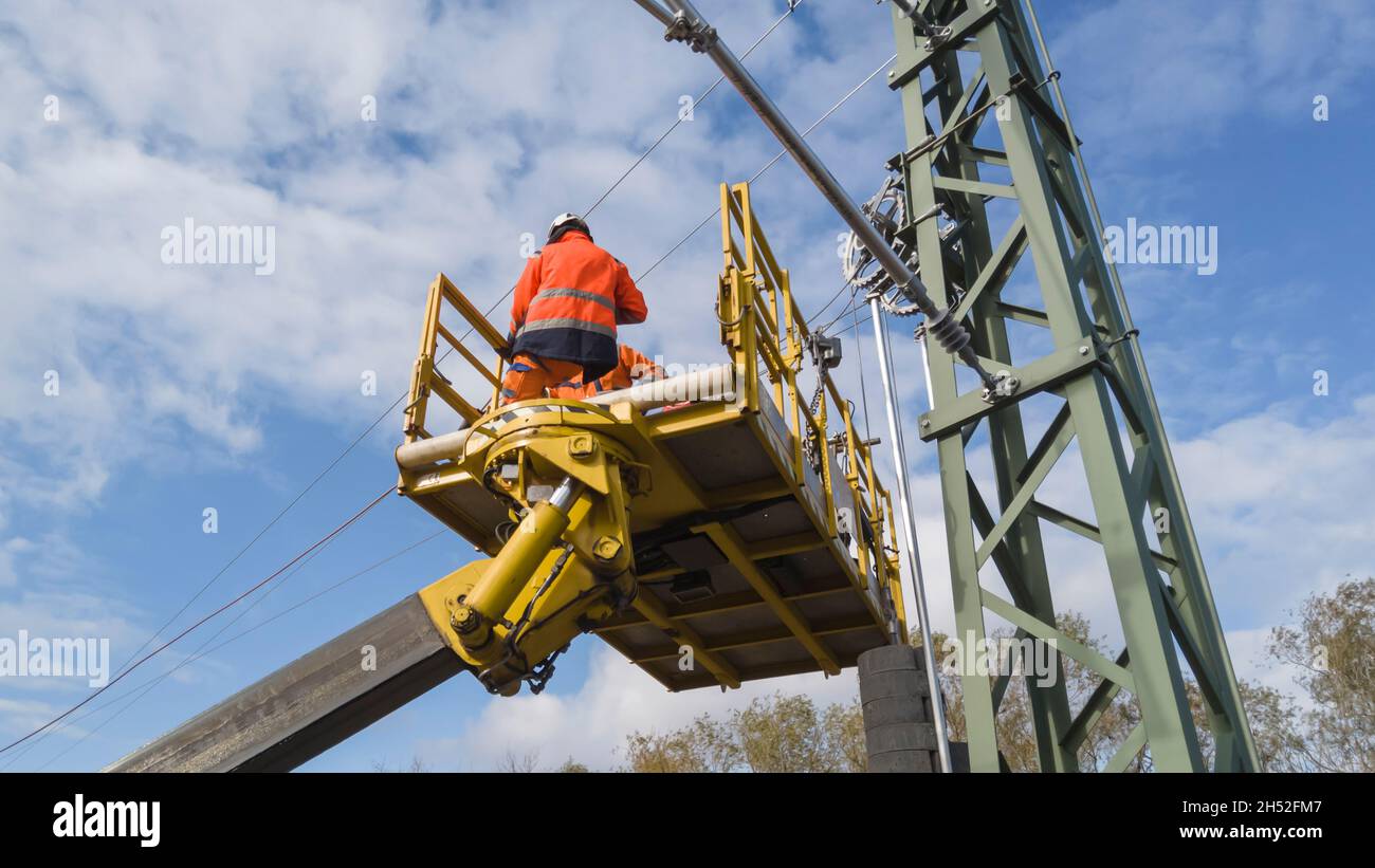 Montatori di linea catenaria che lavorano su un dispositivo di tensionamento Foto Stock