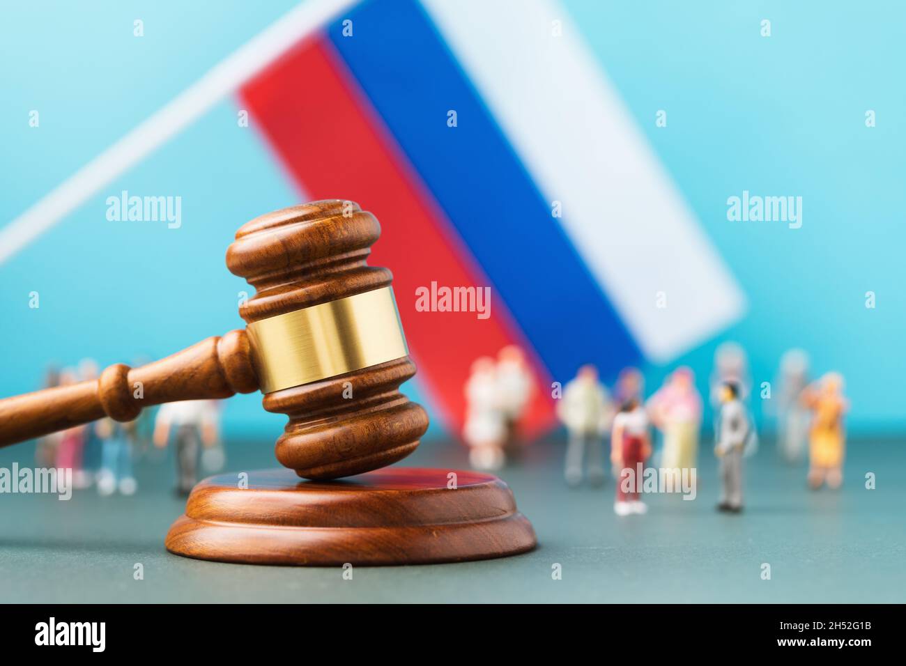 Giudice Gavel, sullo sfondo di una bandiera sfocata e uomini di plastica giocattolo, il concetto di contenzioso nella società russa Foto Stock