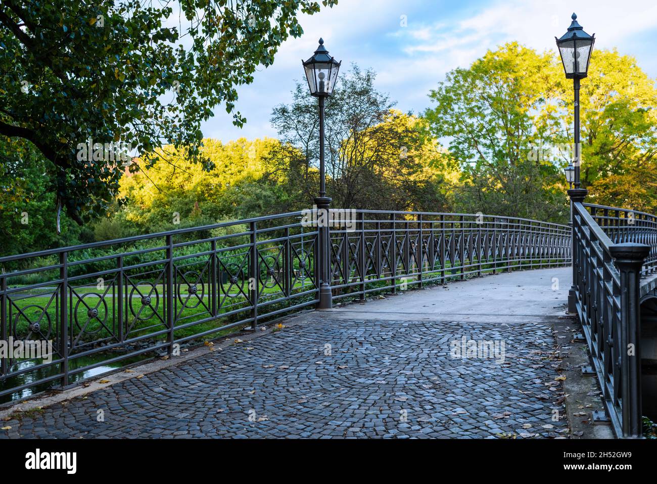Una passerella in ferro attraversa il fiume in una splendida giornata di sole. Foto Stock
