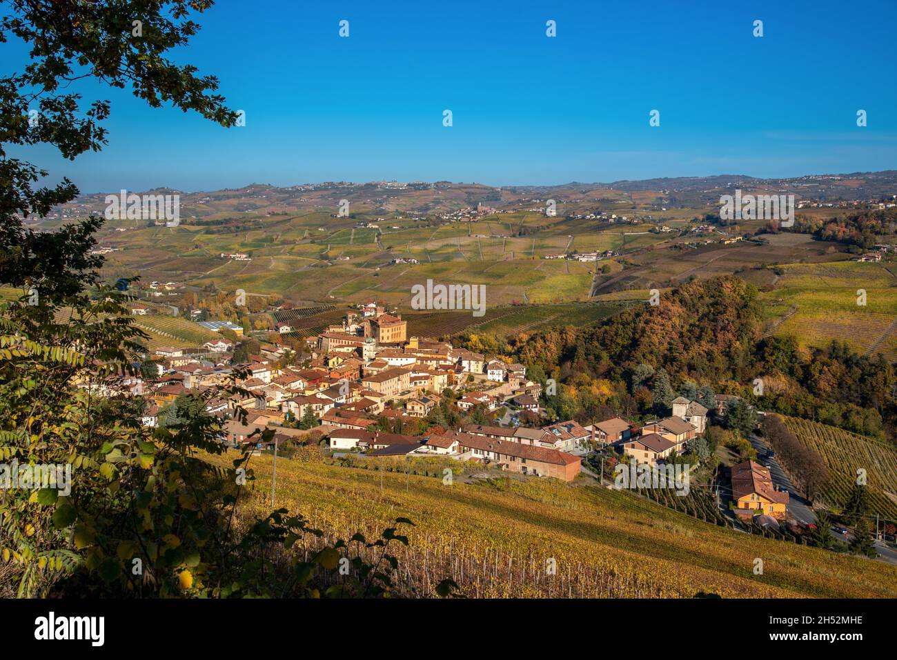 Panorama sul Barolo Village, Cuneo, Italia, tra i vigneti colorati d'autunno sulle colline delle Langhe Foto Stock