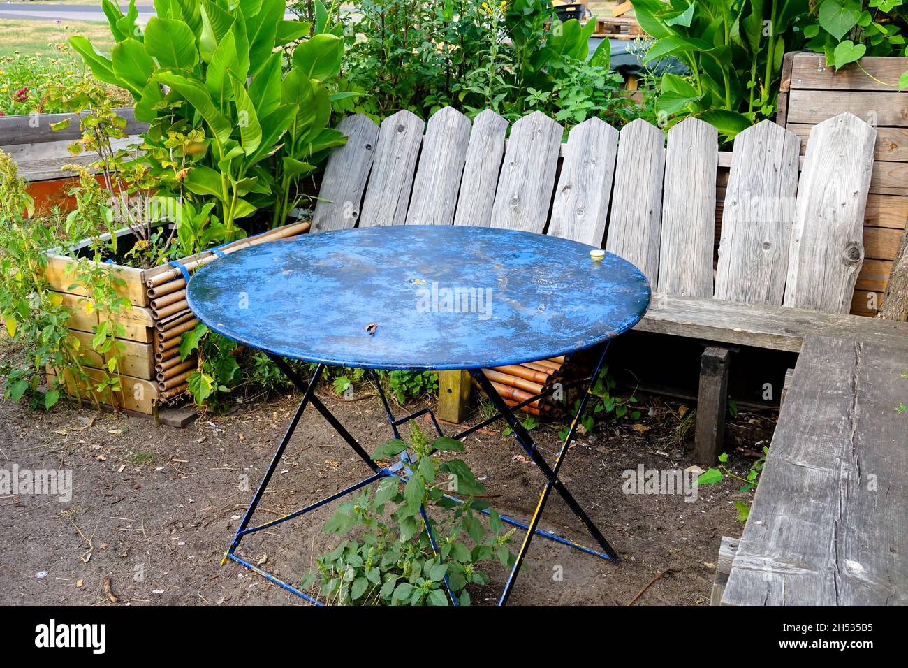 Sedile giardino insolita vecchia seduta in legno con un tavolo in metallo in un giardino di assegnazione Foto Stock