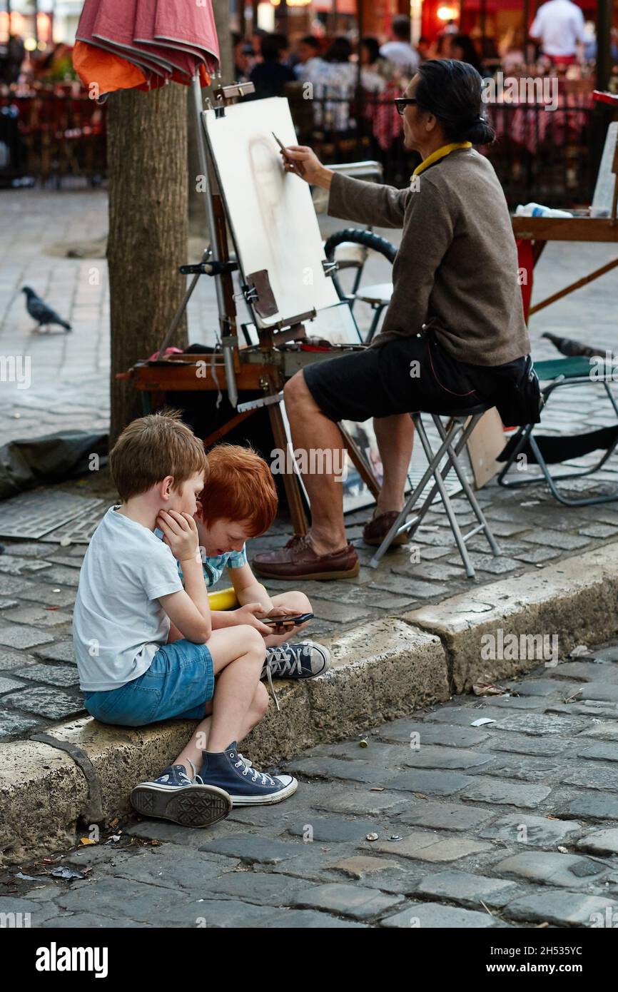 Parigi, Francia - Luglio 2019: Pittore di Montmartre che disegna un ritratto a Place du Tertre, a pochi passi dalla Basilica del Sacro di Montmartre Foto Stock