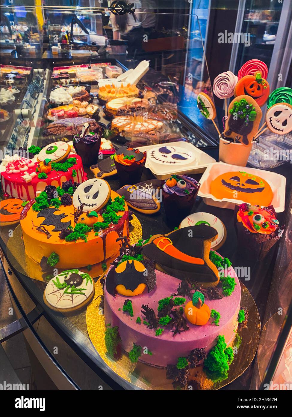 Varietà di torte decorate nello stile di Halloween nella finestra della pasticceria. Foto Stock