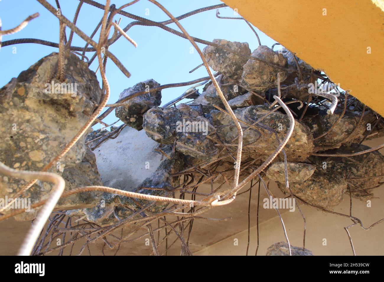 Residui di calcestruzzo che vengono attaccati all'acciaio strutturale dopo la demolizione di un soffitto Foto Stock