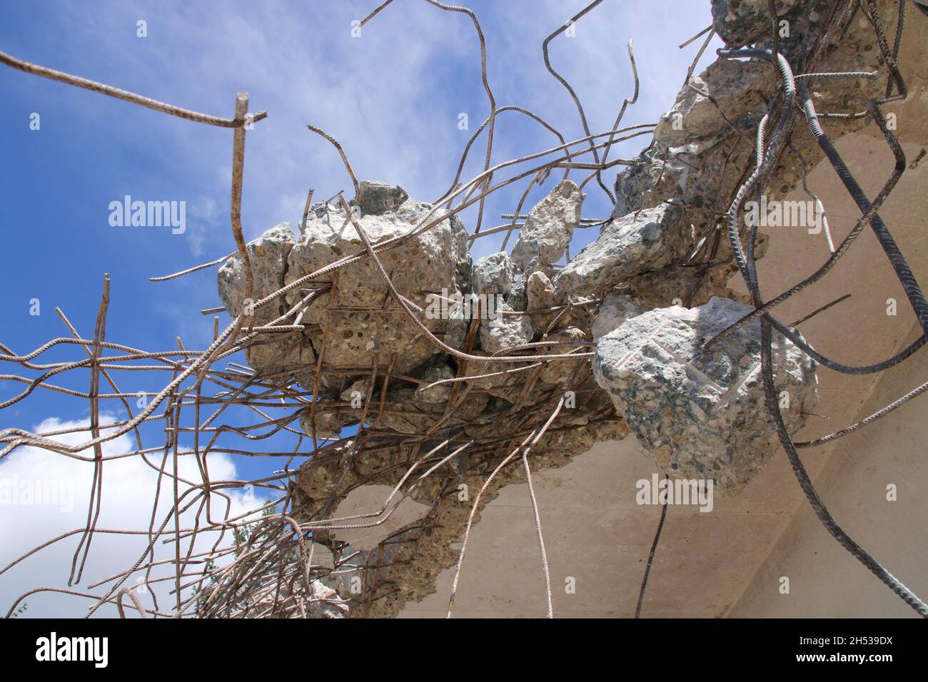 Residui di calcestruzzo che vengono attaccati all'acciaio strutturale dopo la demolizione di un soffitto Foto Stock