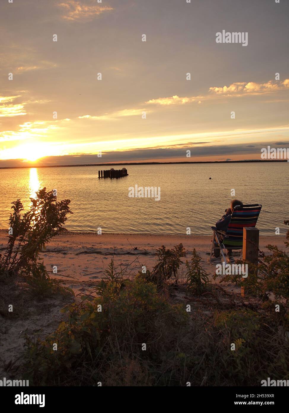 Il New Jersey tramonta sulla baia di Barnegat nella contea di Ocean. Una tonalità dorata è evidente insieme alle calme acque della baia. Foto Stock