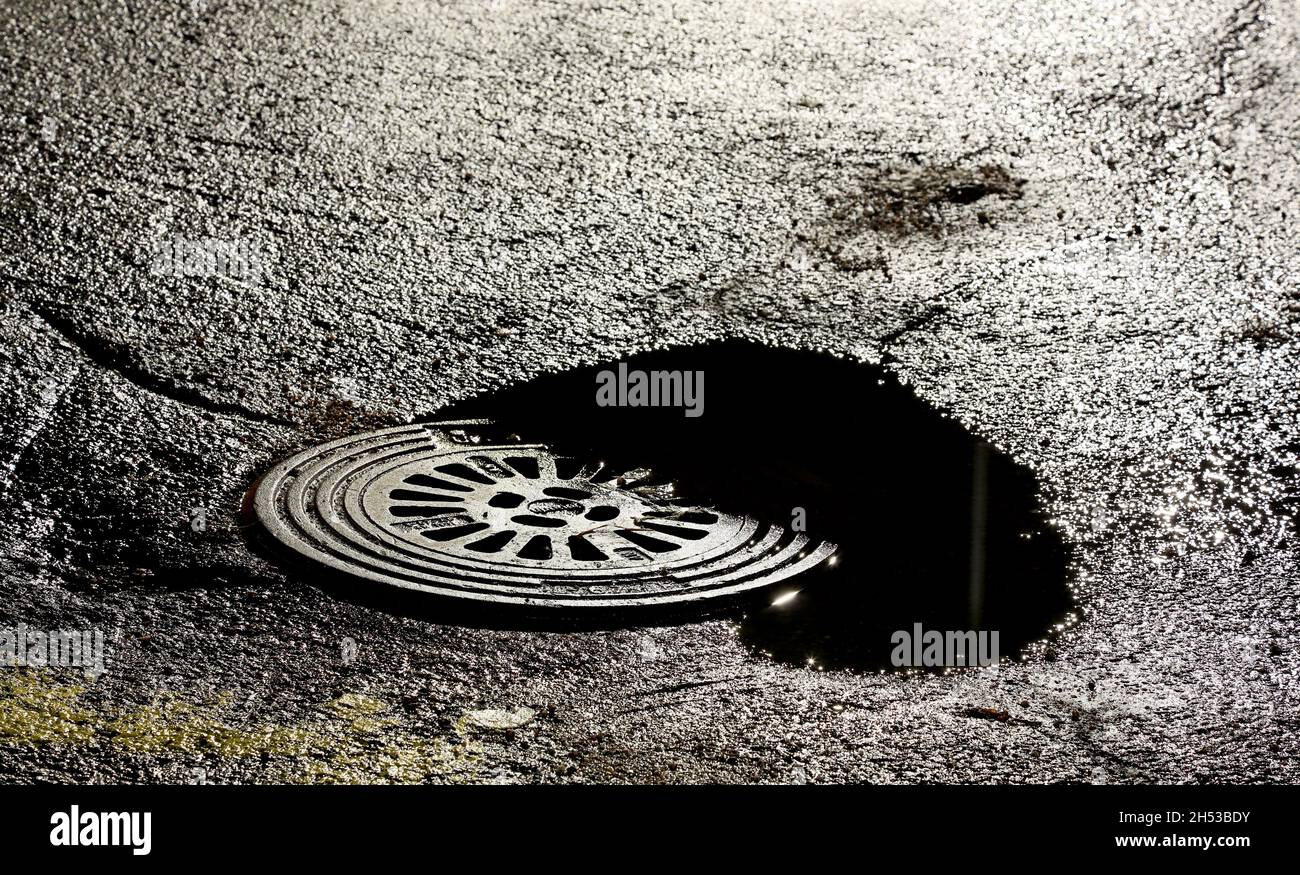 Insenatura di strada dopo la pioggia doccia a tarda notte Foto Stock