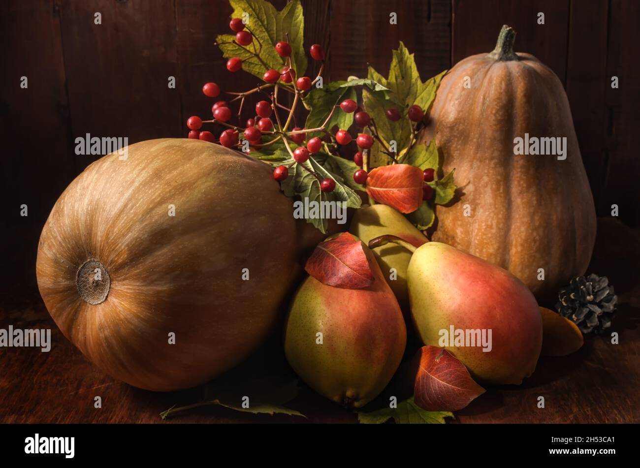 pere mature e zucca su sfondo di legno scuro in stile rustico Foto Stock