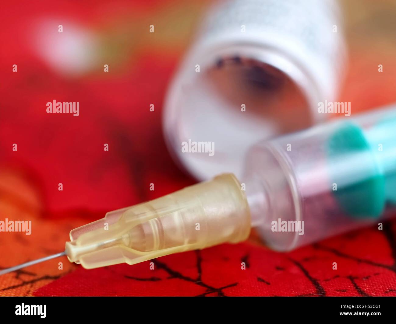 Fiala per vaccinazione con siringa contro il virus covid-19 o Corona su fogli rossi Foto Stock