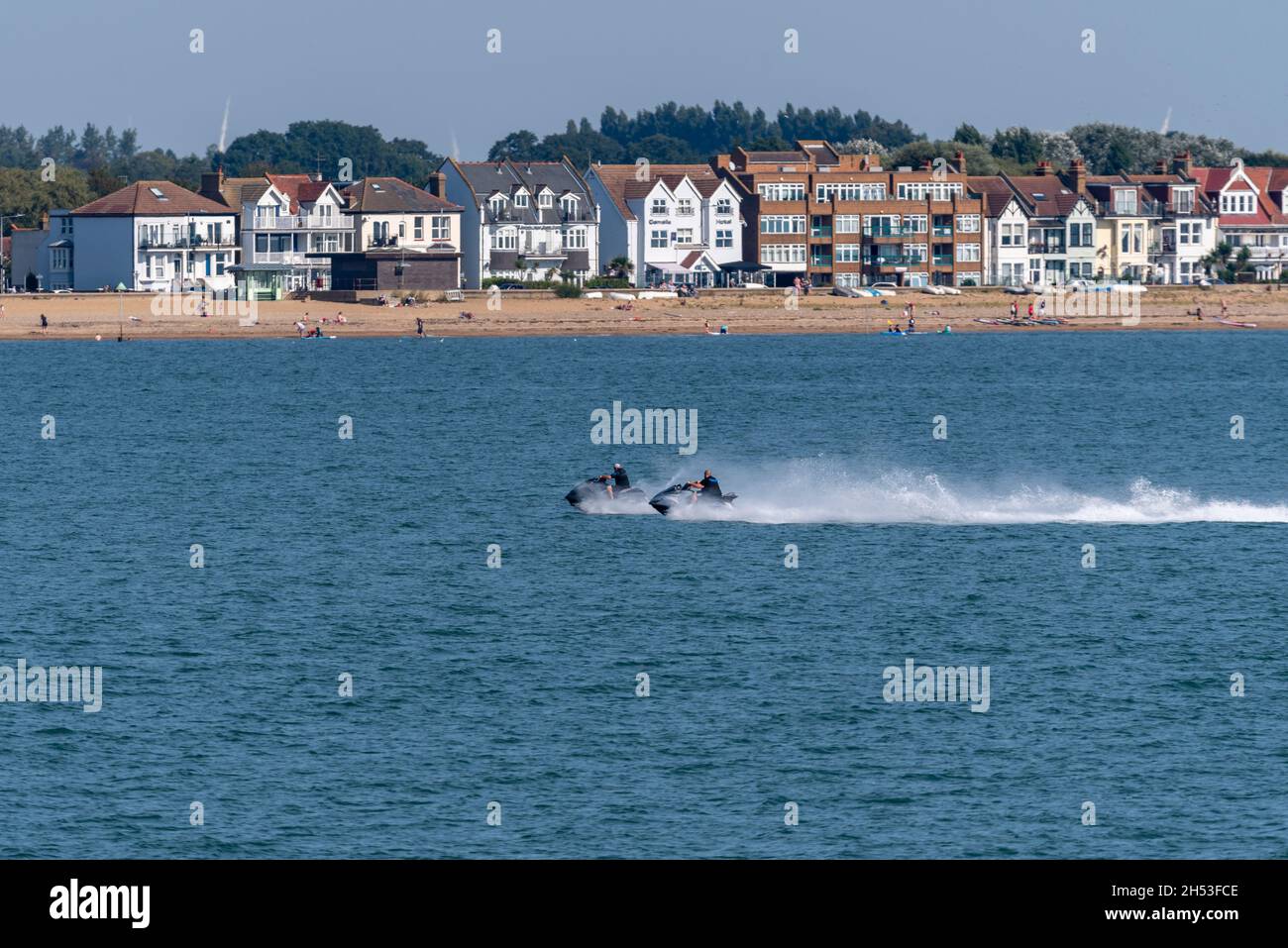 I motociclisti del jet ski si aggettano davanti al lungomare di Southend on Sea, essex, Regno Unito, visto dal molo di Southend nell'estuario del Tamigi. Spiaggia, costa, proprietà Foto Stock