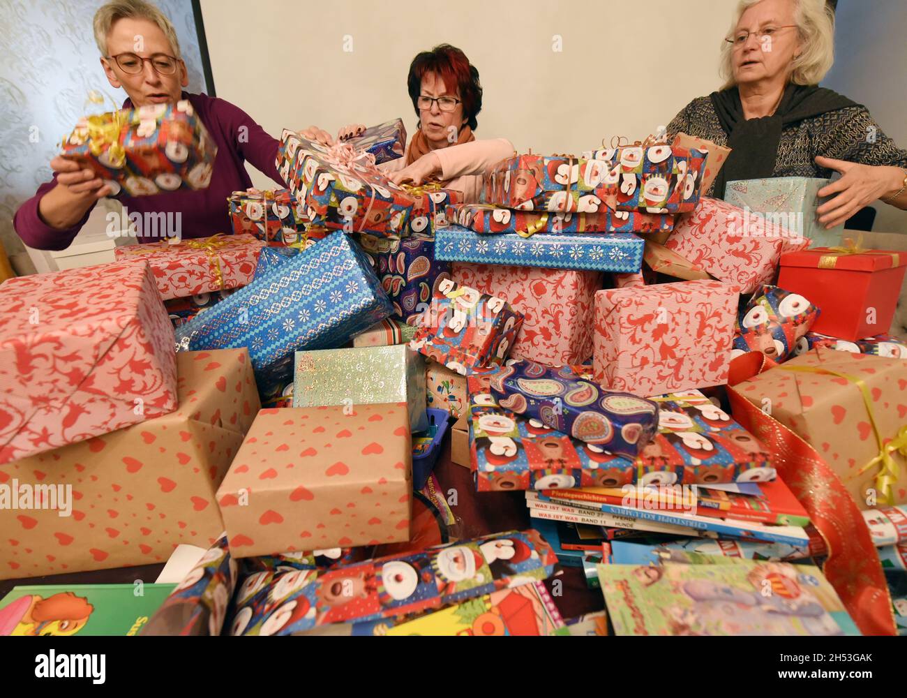 Lipsia, Germania. 6 novembre 2021. Le donne dello Zonta Club Leipzig confezionano oltre 200 pacchetti con donazioni raccolte in natura, tra cui libri, bambole, ceramiche, animali ripieni e articoli per il benessere in vendita presso un mercatino di Natale. I proventi dell'azione sono di andare come donazione a una casa di bambini in Ahrtal colpiti dall'acqua alta. Zonta International è stata fondata nel 1919 negli Stati Uniti ed è particolarmente impegnata per i diritti delle donne. (A dpa 'Leipzig women's club Zonta packs pacchi pacchi pacchi per alluvione') Credit: Waltraud Grubitzsch/dpa-Zentralbild/dpa/Alamy Live News Foto Stock