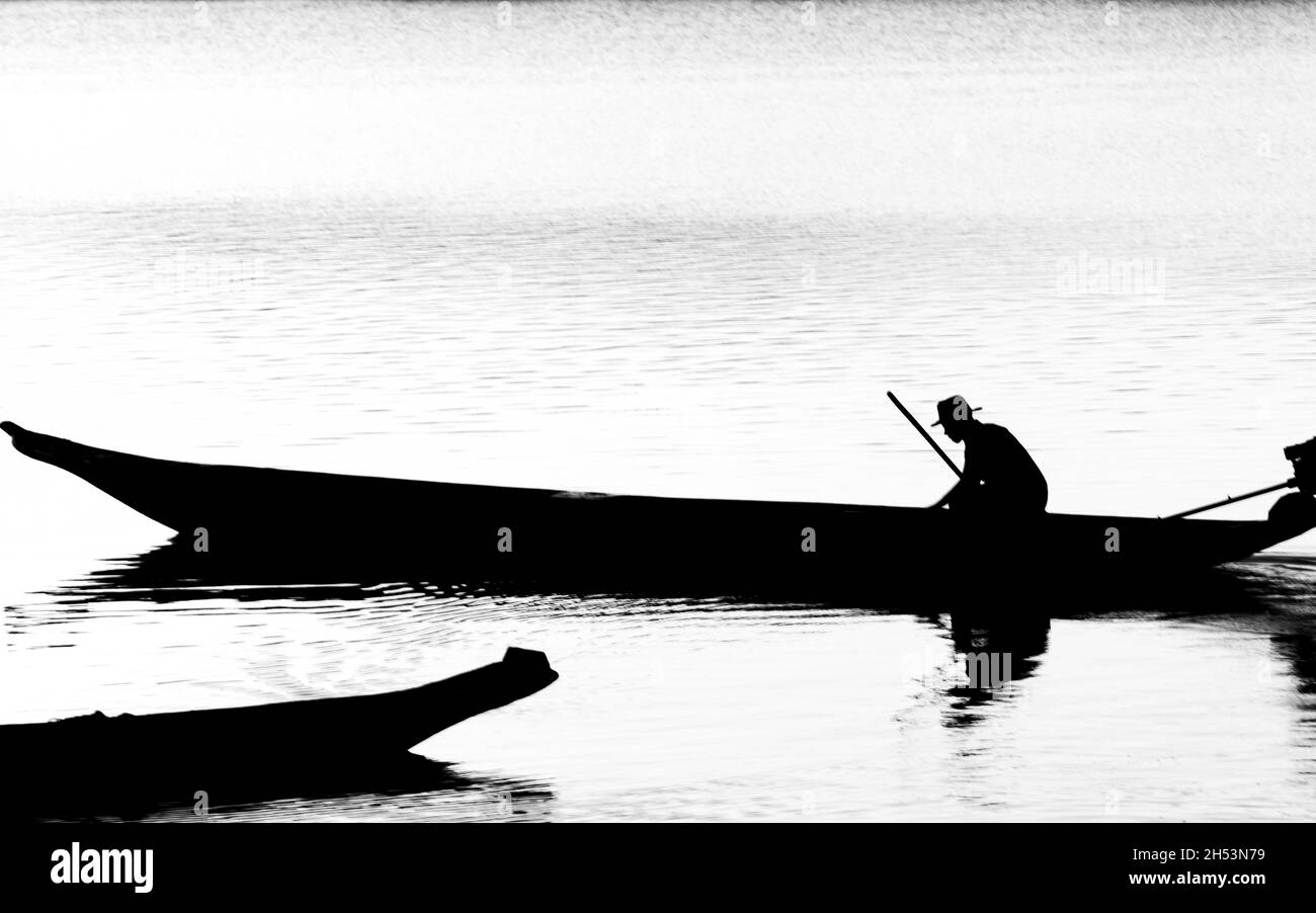 Cachoeira, Bahia, Brasile - 29 novembre 2014: Silhouette al tramonto di un pescatore nella sua barca sul grandioso fiume Paraguacu, situato nel Brazili Foto Stock