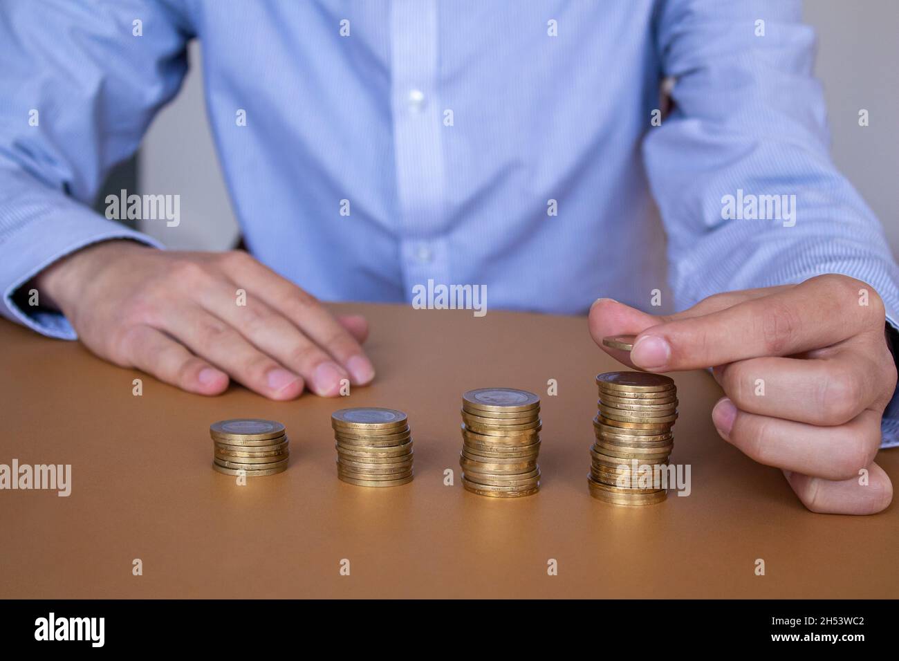 Businessman accatastare monete sul tavolo, business Growth Concept. Mano mette la moneta per impilare. Foto Stock