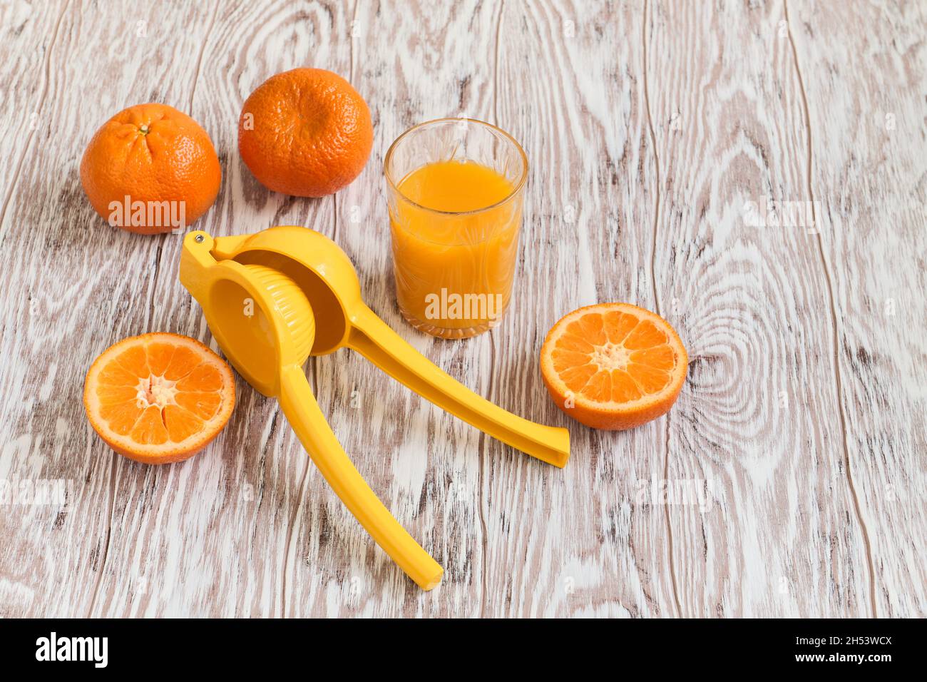 I tangerini o le clementine si trovano vicino a un bicchiere di succo appena spremuto, poco profondo di campo Foto Stock