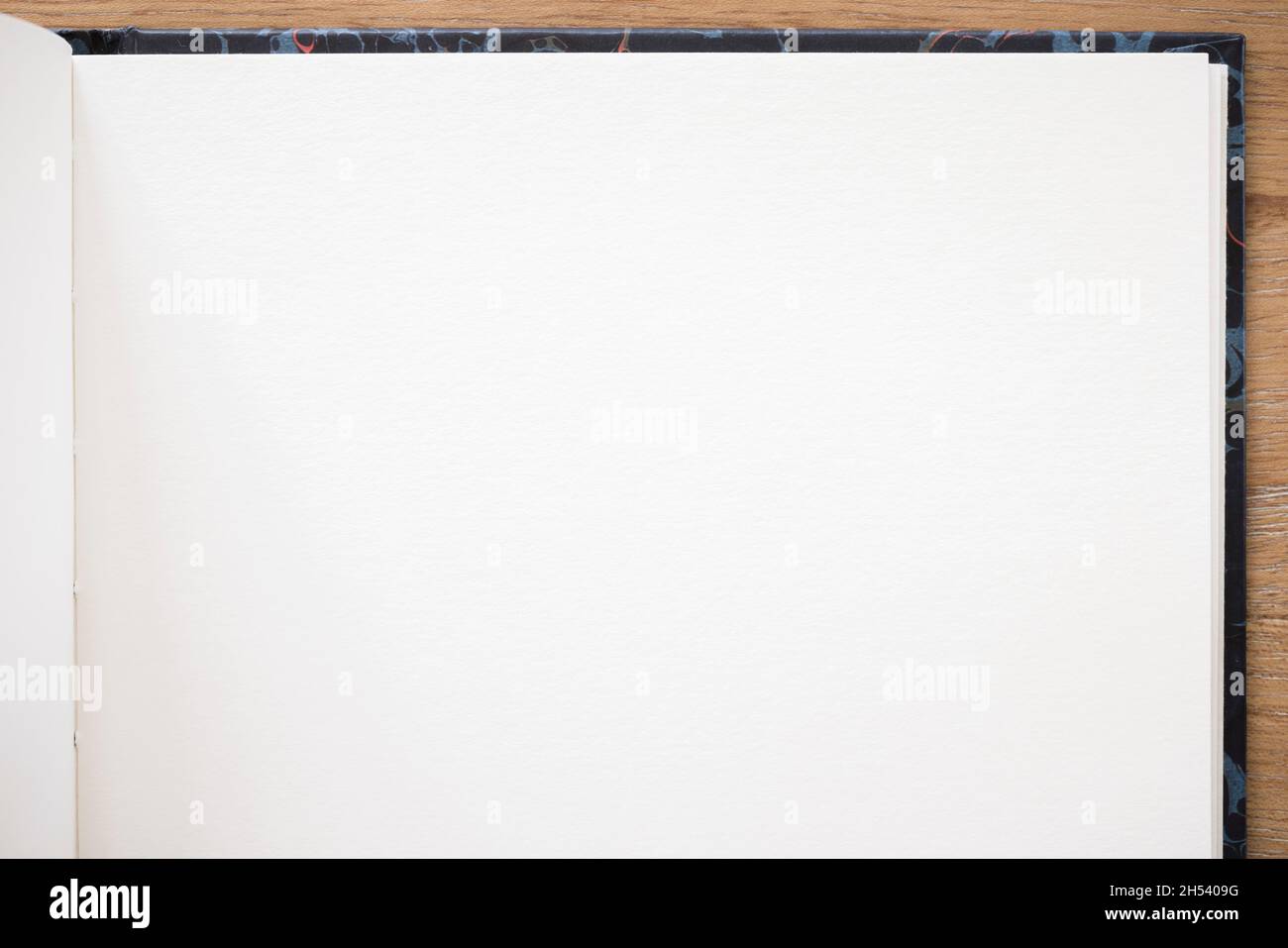 Notebook con carta bianca comune e supporto rigido aperto su una scrivania in legno Foto Stock